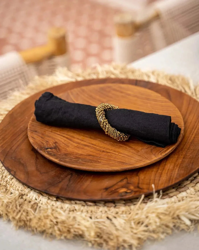 Assiette en racine de teck ronde avec serviette noire et anneau de perles