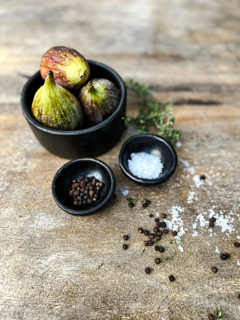 Figs avec sel et poivre dans l’ensemble de 3 Le plat cylindrique brûlé noir