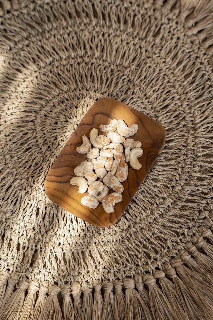 Cashews sur un plateau en bois de teck pour le plat d’accompagnement rectangulaire