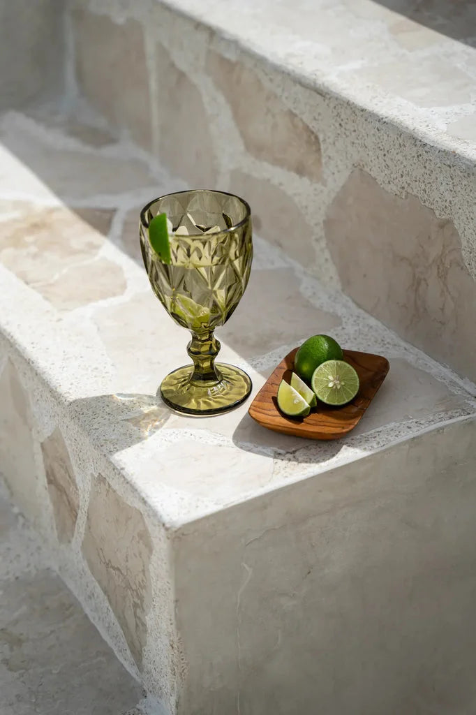 Verre vert en verre avec des limes, associé au plat d’accompagnement en racine de teck rectangulaire