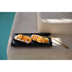 Toast avec cream cheese, pêches tranchées et noix sur plateau à sushi en terre cuite noire