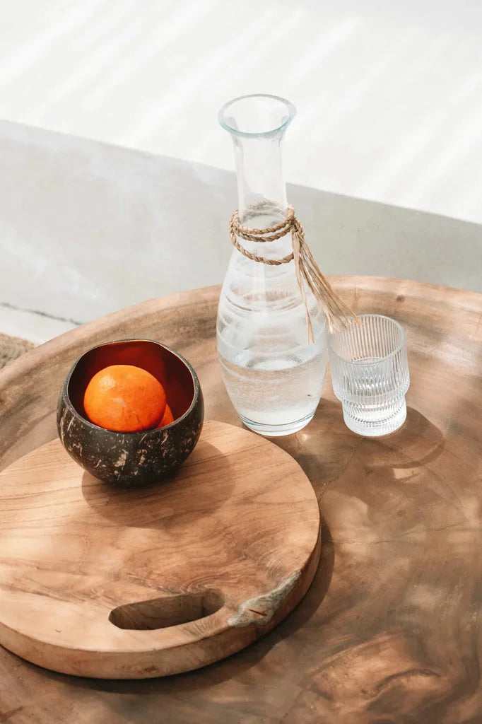 Nature morte avec orange, eau et bois sur le plateau en racine de teck naturel M
