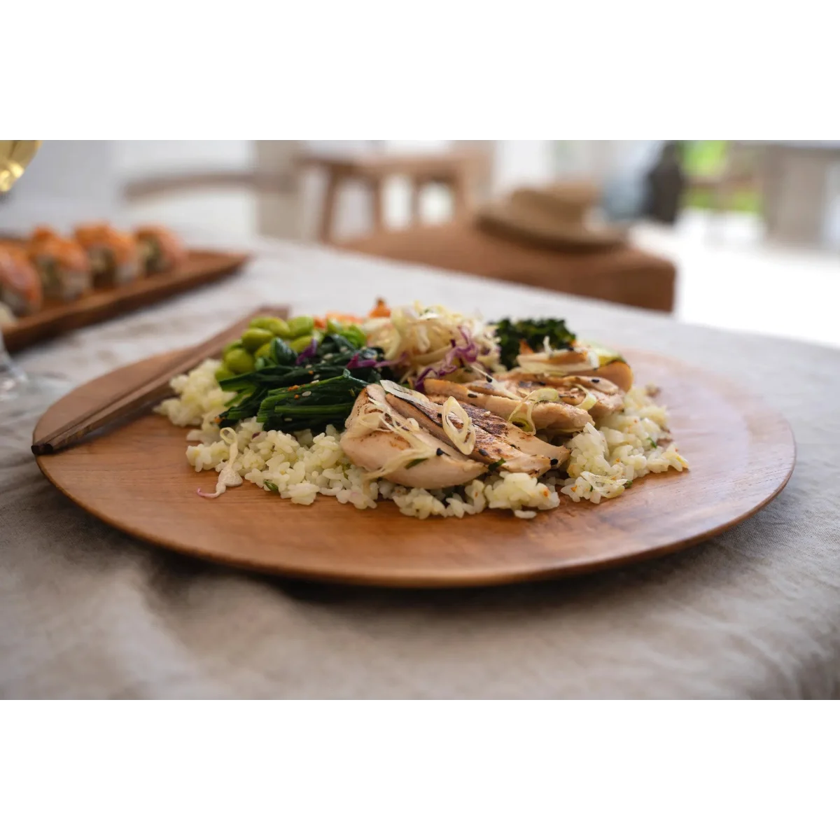 Bol de poulet grillé et légumes avec riz dans un plateau rond en racine de teck naturel
