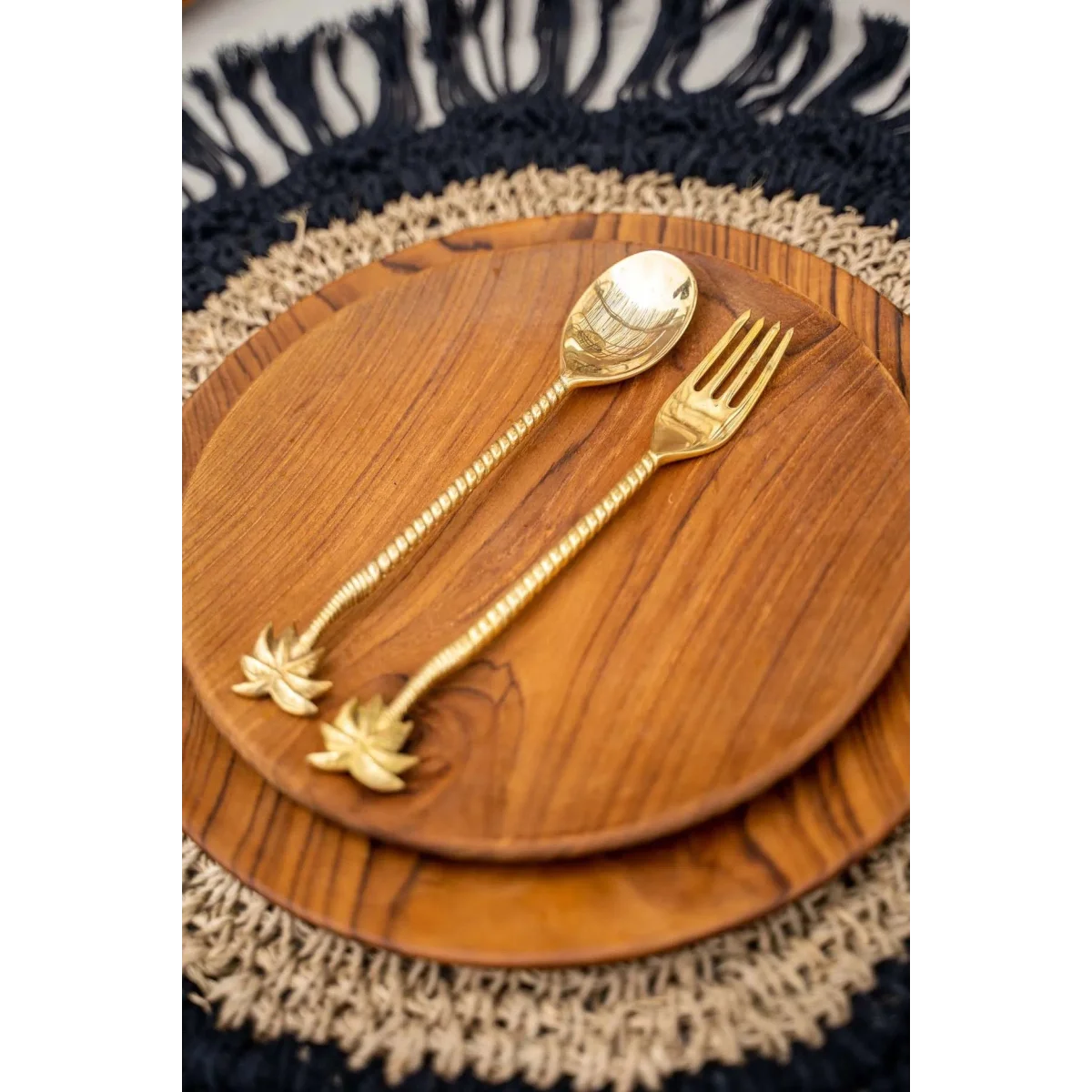 Set de cuillères et fourchettes à poignée en palmier doré sur assiettes en bois naturel