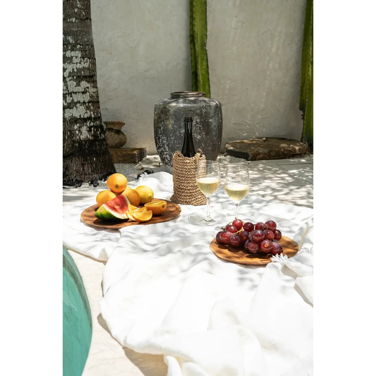 Plateau rond en racine de teck avec pique-nique tropical, vin, fruits et raisins