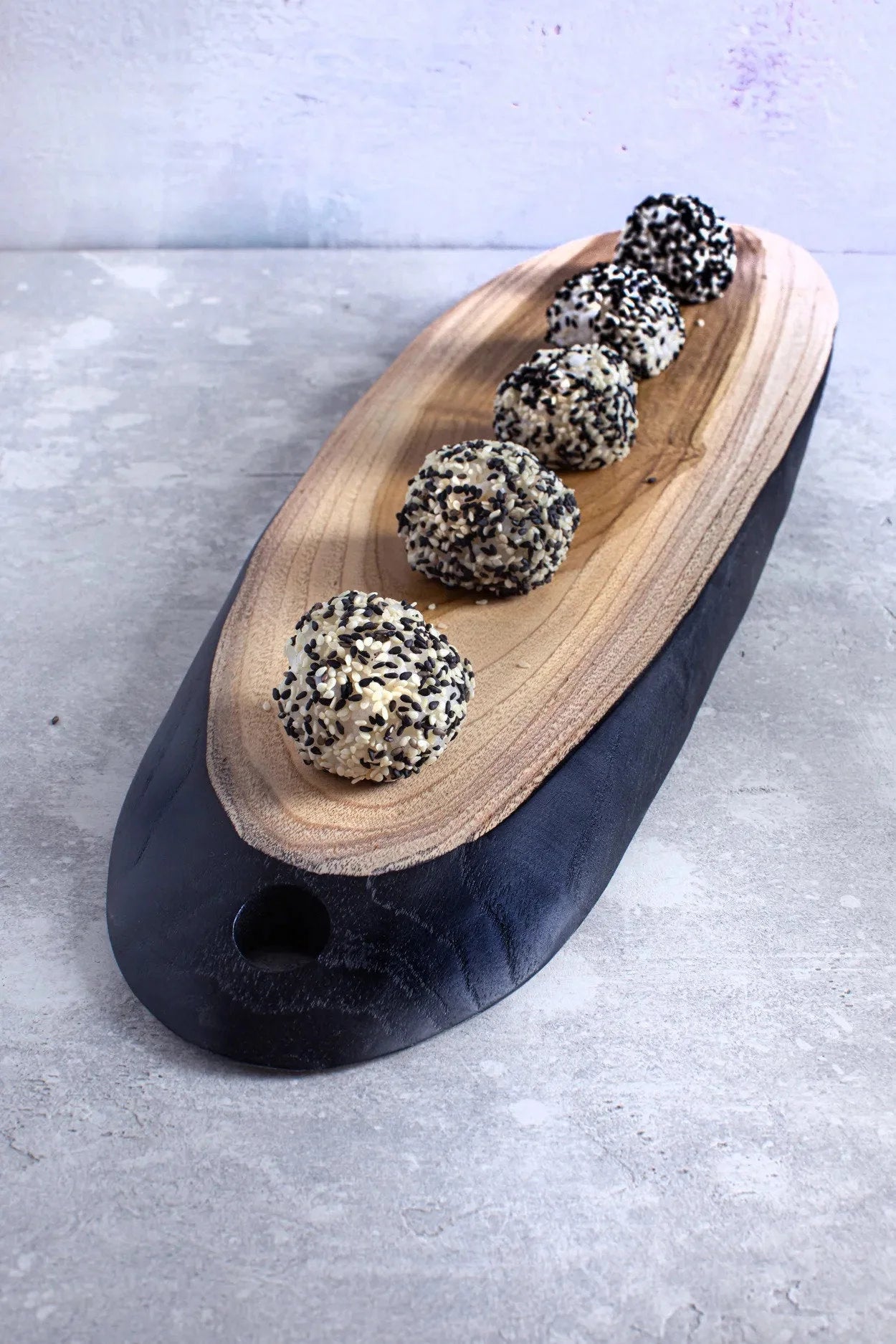Plateau en teck allongé bicolore pour tapas avec truffes aux graines de sésame