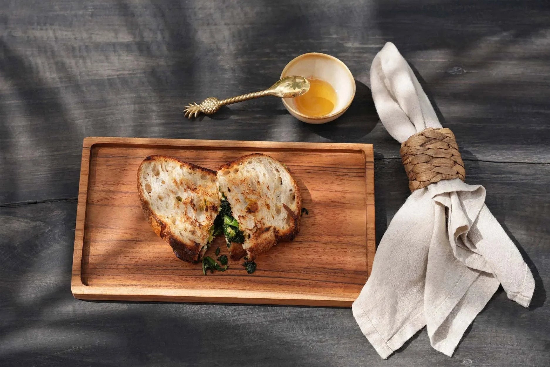 Sandwich en forme de cœur sur planche à découper en teck naturel