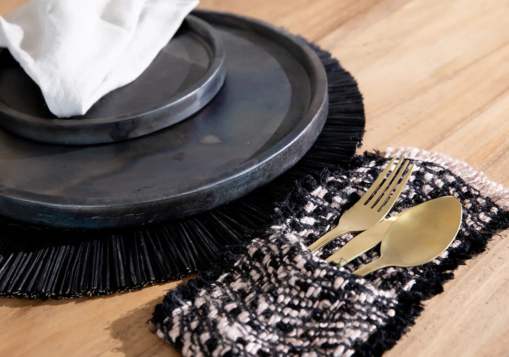Couverts en or et assiettes noires élégantes pour une table sophistiquée