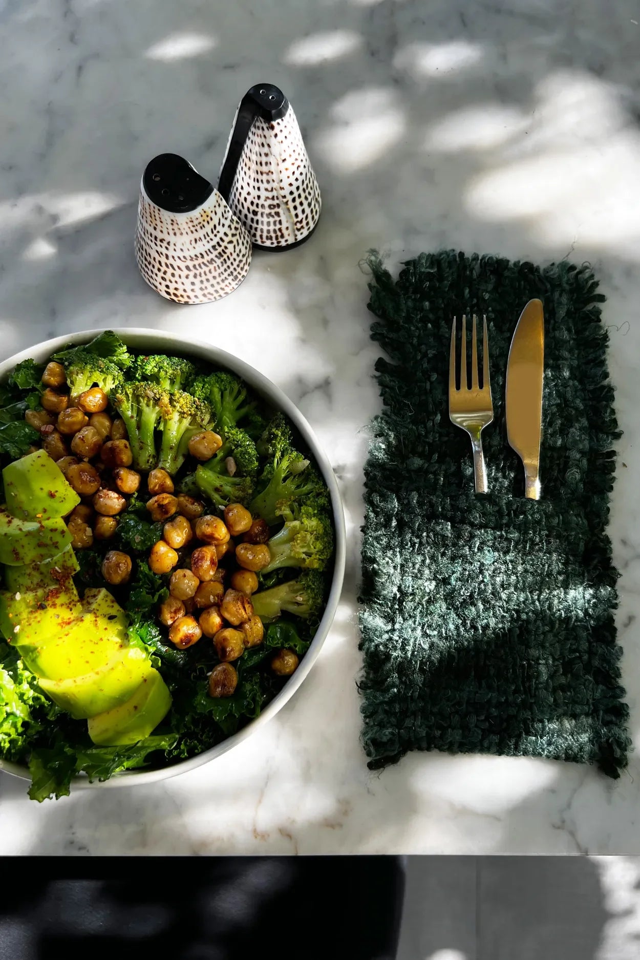 Salade saine avec avocat et pois chiches dans des pochettes à couverts en coton vert foncé