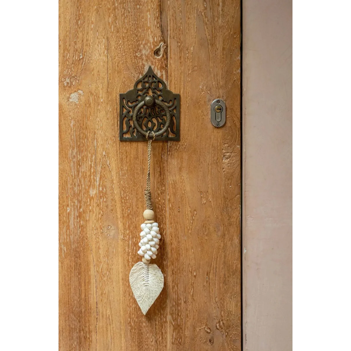 Poignée de porte en métal ornée d’une feuille décorative et d’une perle à pompon