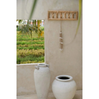 Vase céramique blanc avec accents argentés et design moderne, pompon en coquillages blancs et cordes naturelles