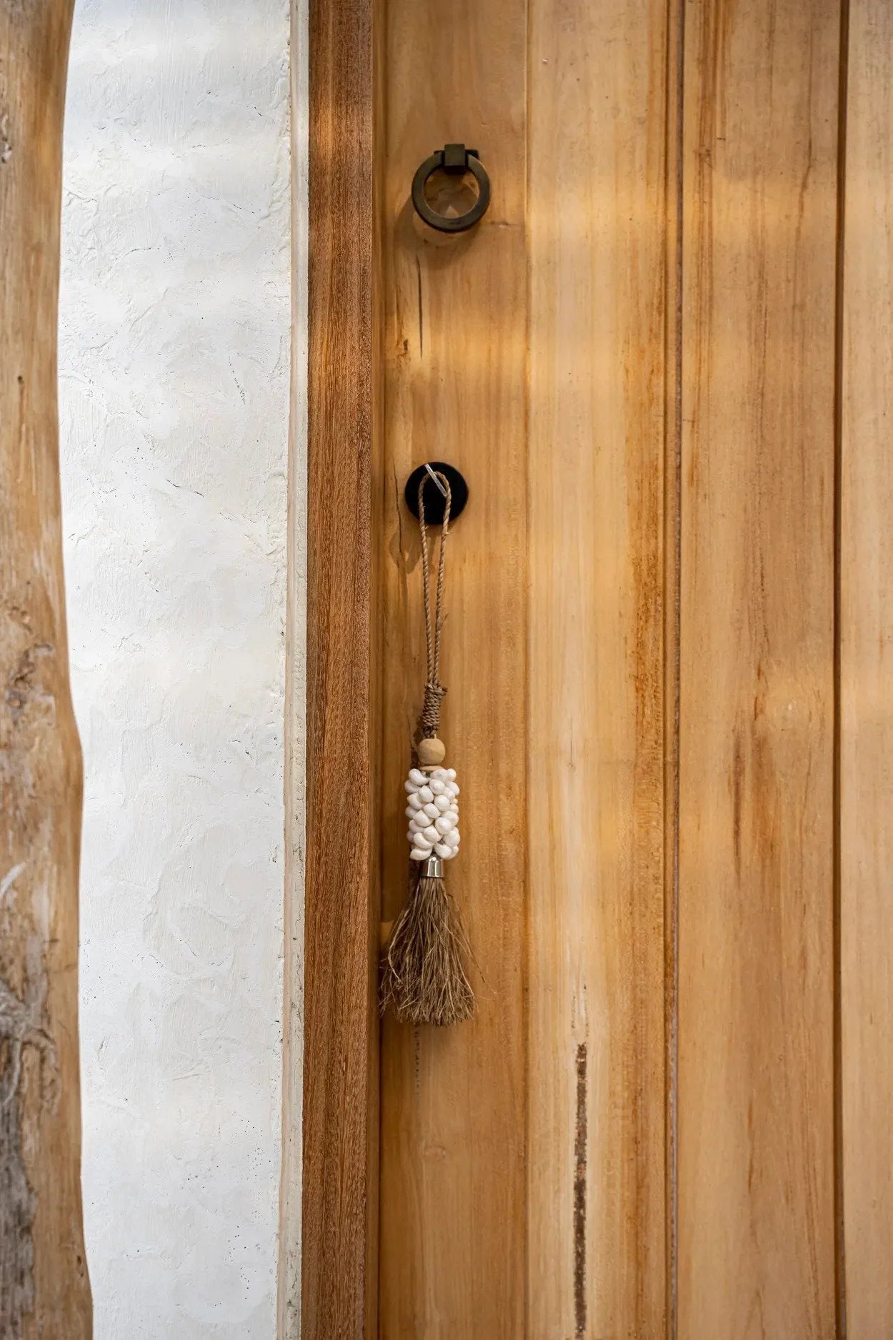 Porte en bois avec pompon mural artisanal en coquillages cauris et Raphia naturel