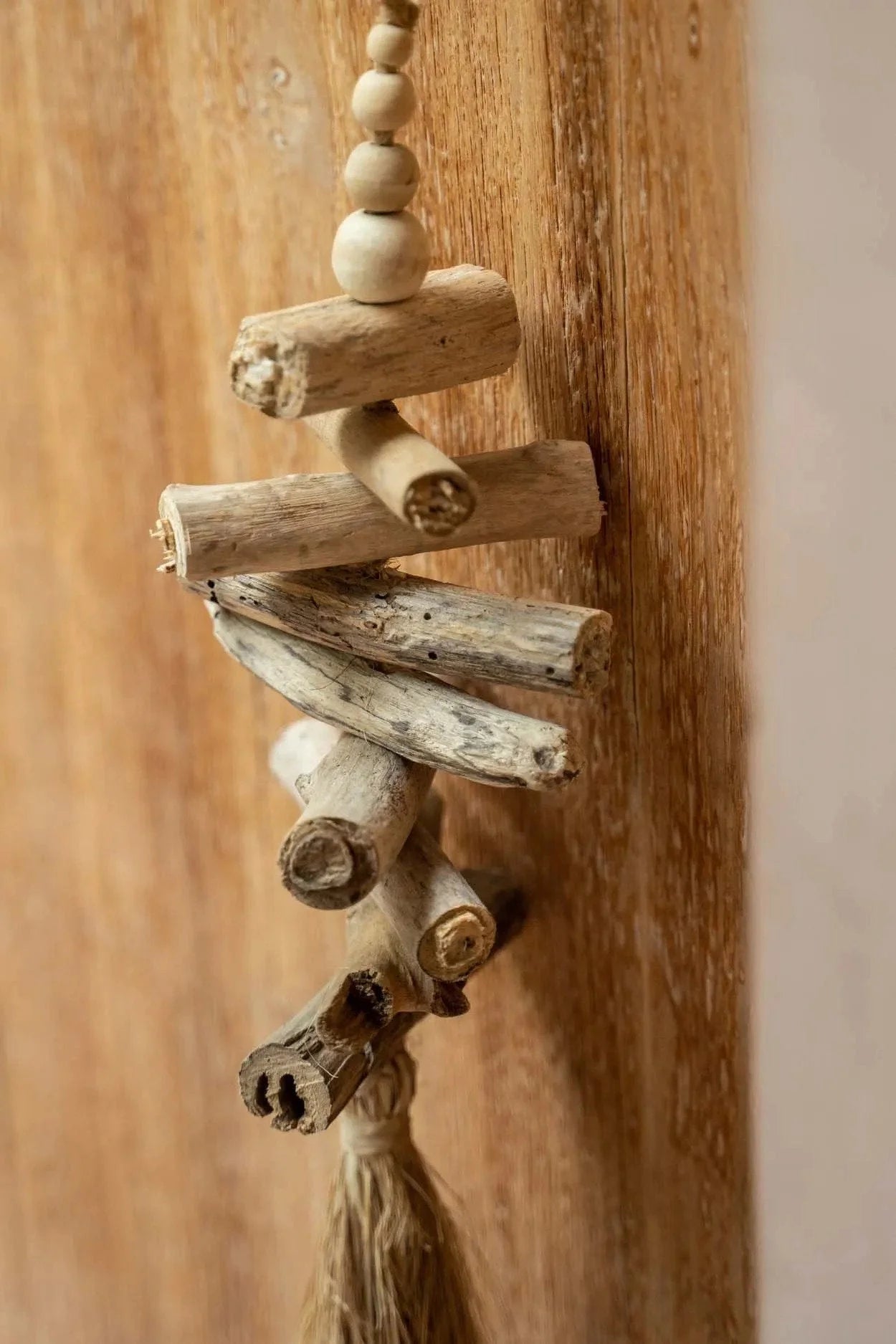 Mural pompon en bois flotté et raphia, forme sapin stylisé