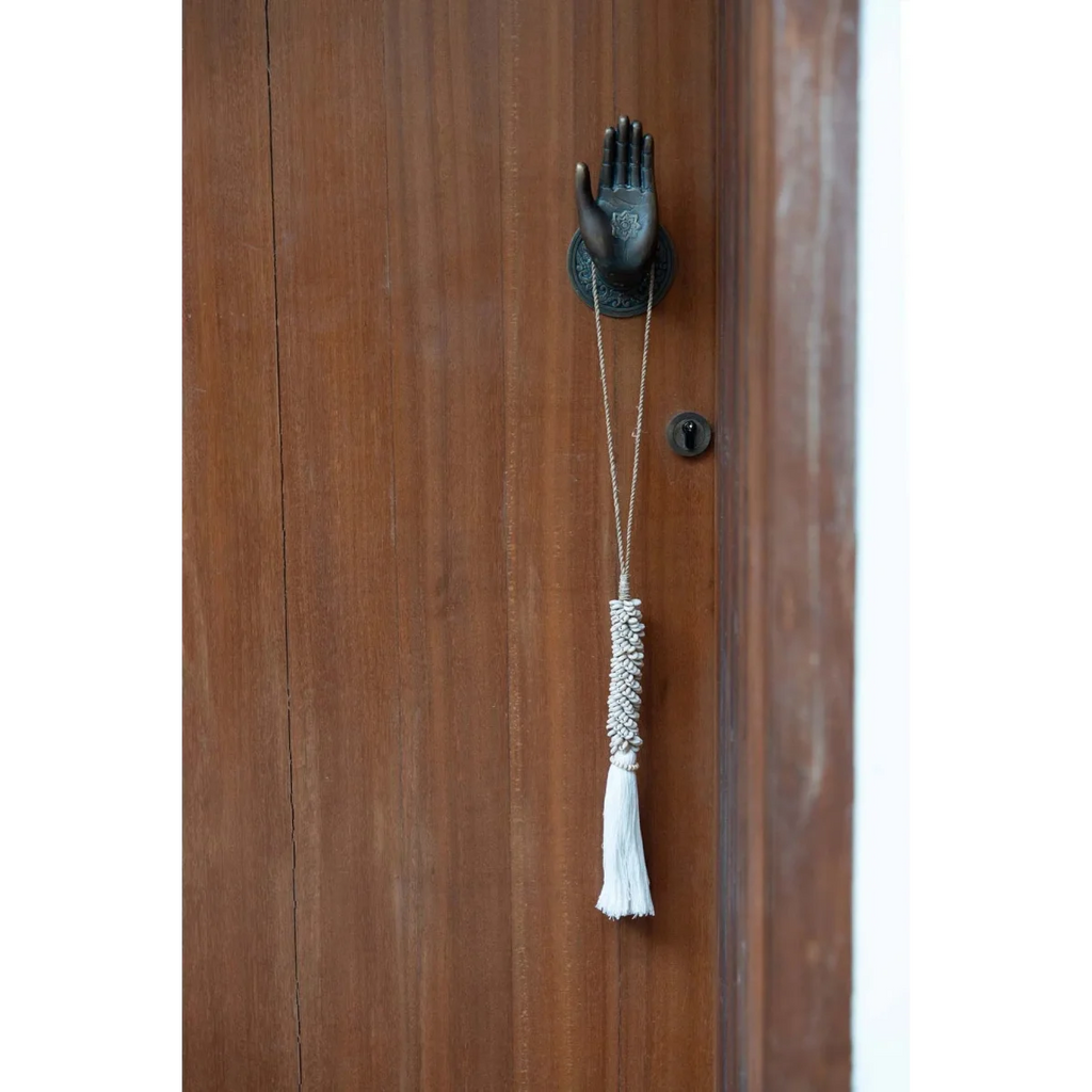 Heurtoir porte main en bois brun avec pompon et accents métalliques