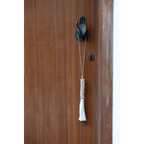 Heurtoir porte main en bois brun avec pompon et accents métalliques