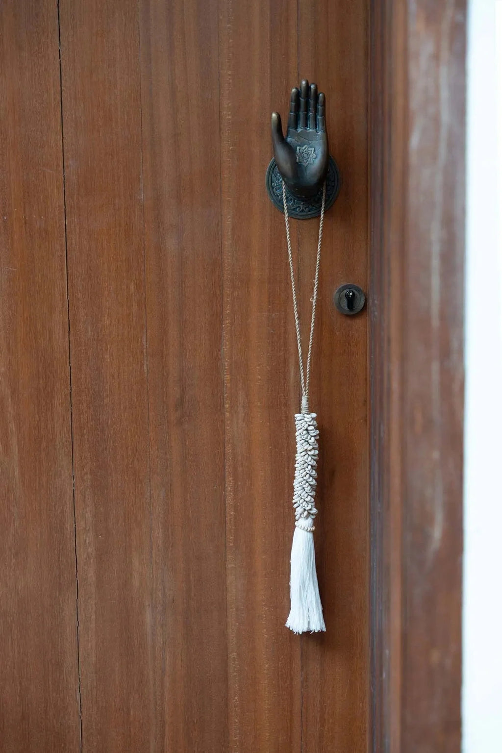 Heurtoir de porte en forme de main avec pompon en coton et cauris