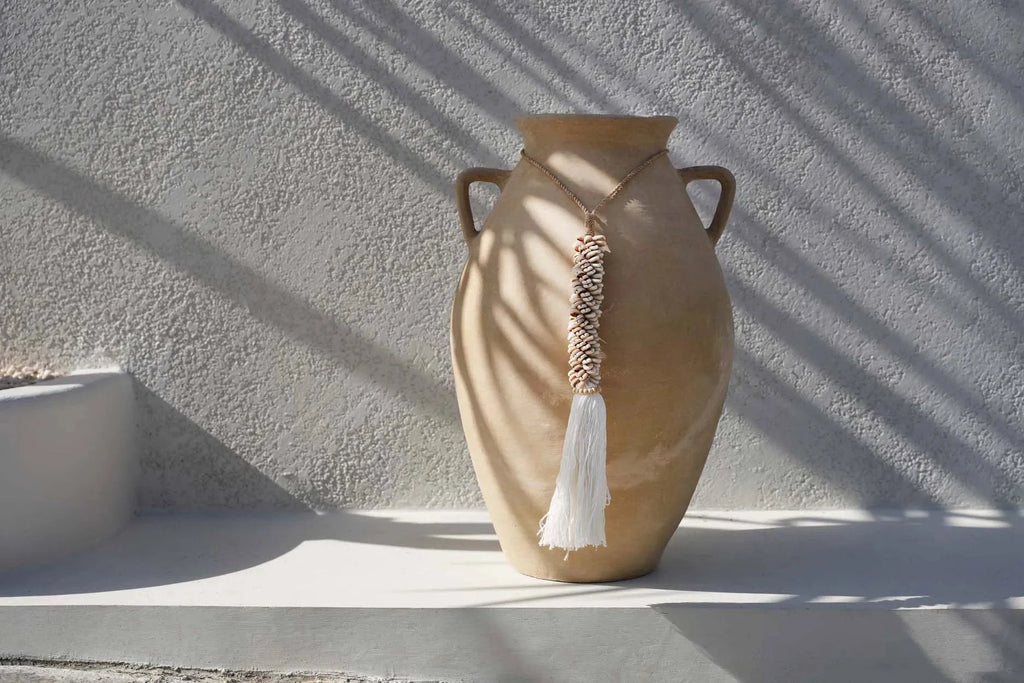 Vase en céramique tan avec anses dorées et franges tissées