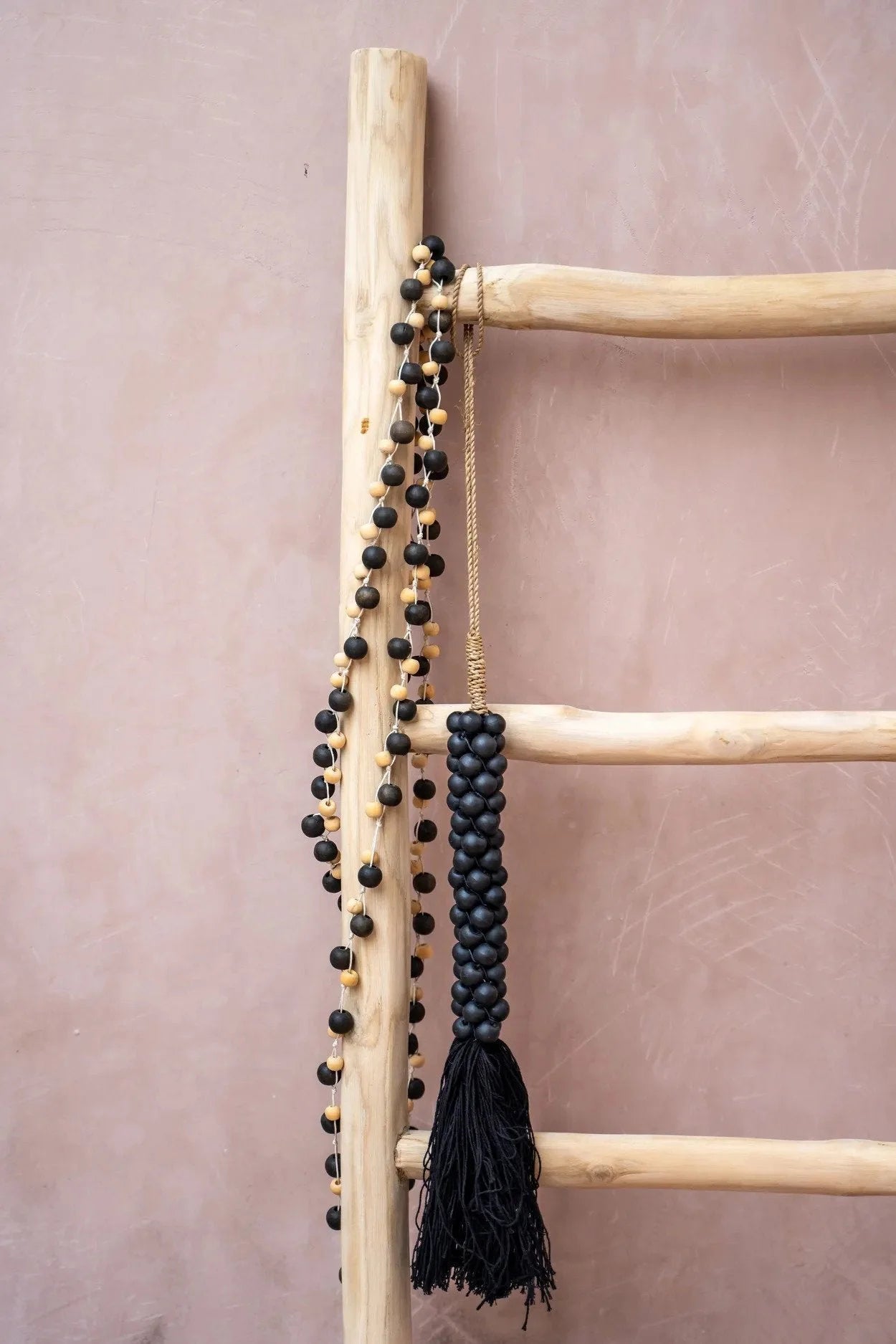 Échelle en bois avec pompons en perles de bois noir et corde naturelle