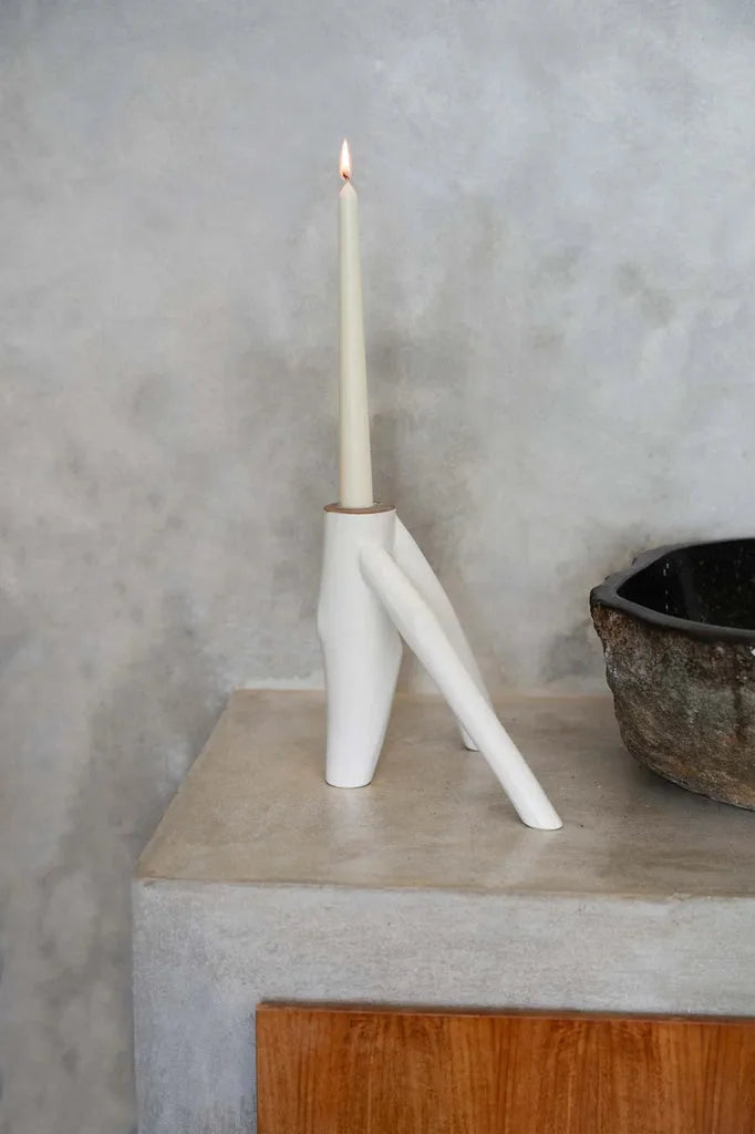 Bougie allumée dans un porte-bougie blanc et abstrait pour la décoration