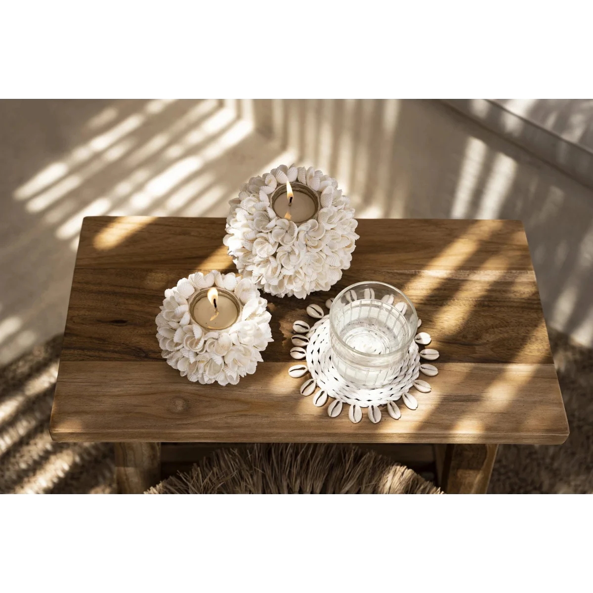 Porte-bougie floral blanc en coquillages sur table bois rustique