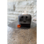 Porte-bougie en grès noir sculpté visage stylisé avec petite fleur orange à la base