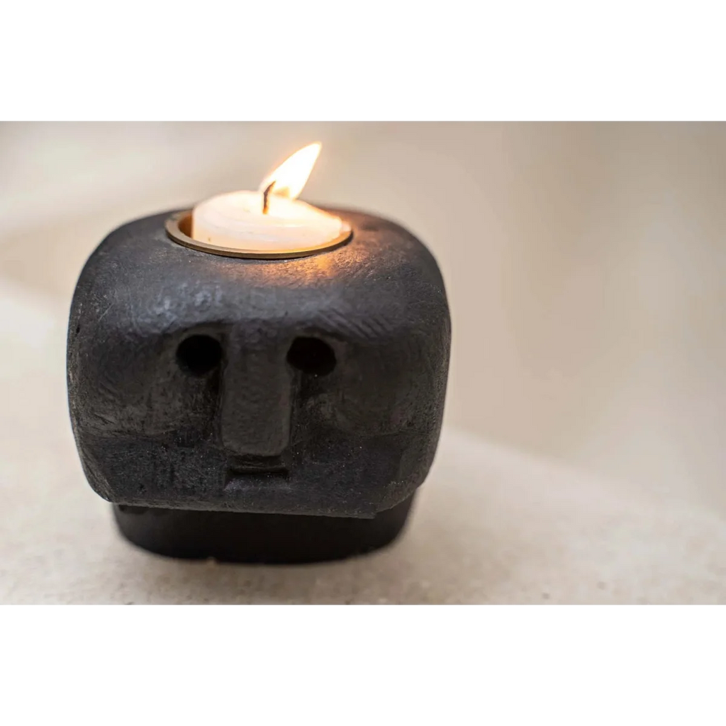 Bougeoir visage en grès noir sculpté avec bougie tea light allumée