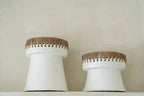 Deux porte-bougies en terre cuite blanc à bord frangé en raphia