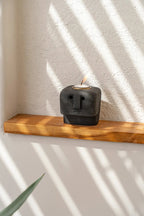 Porte-bougie totem en grès noir sculpté avec motifs géométriques