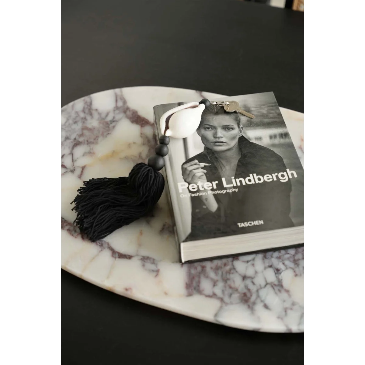 Porte-clés coquillage cauri noir et blanc avec pompon en coton, plateau marbre blanc, pendentif crâne argenté et gland noir