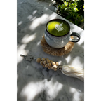 Latte matcha vert avec design feuille dans mug sur sous-verre paille