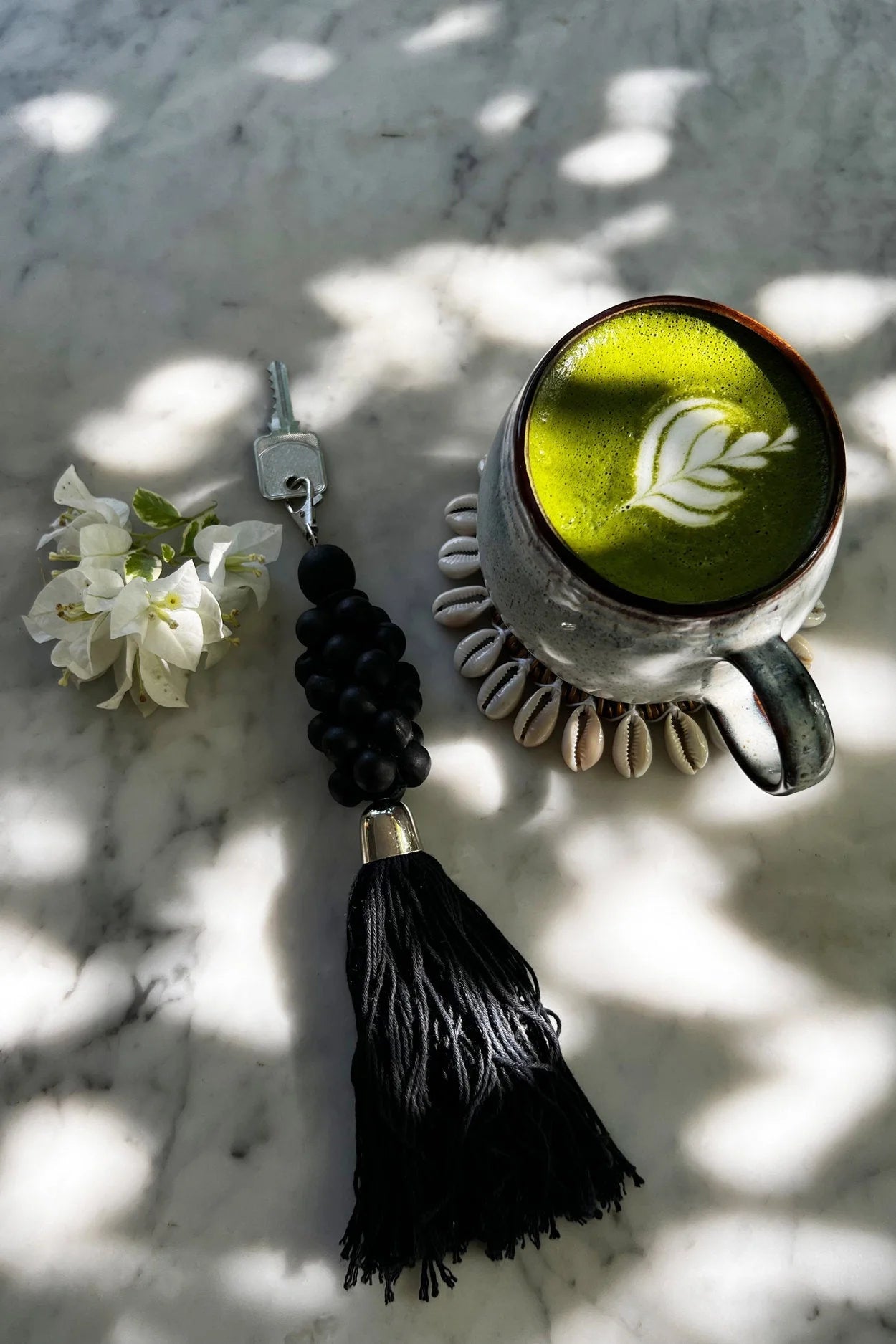 Porte-clés pompon en perles de bois noir à breloques