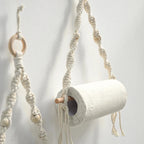 Porte-papier toilette en bois et macramé utilisé pour suspendre une serviette et du papier