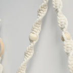 Détail de la perle en bois dans le macramé du porte-papier toilette mural