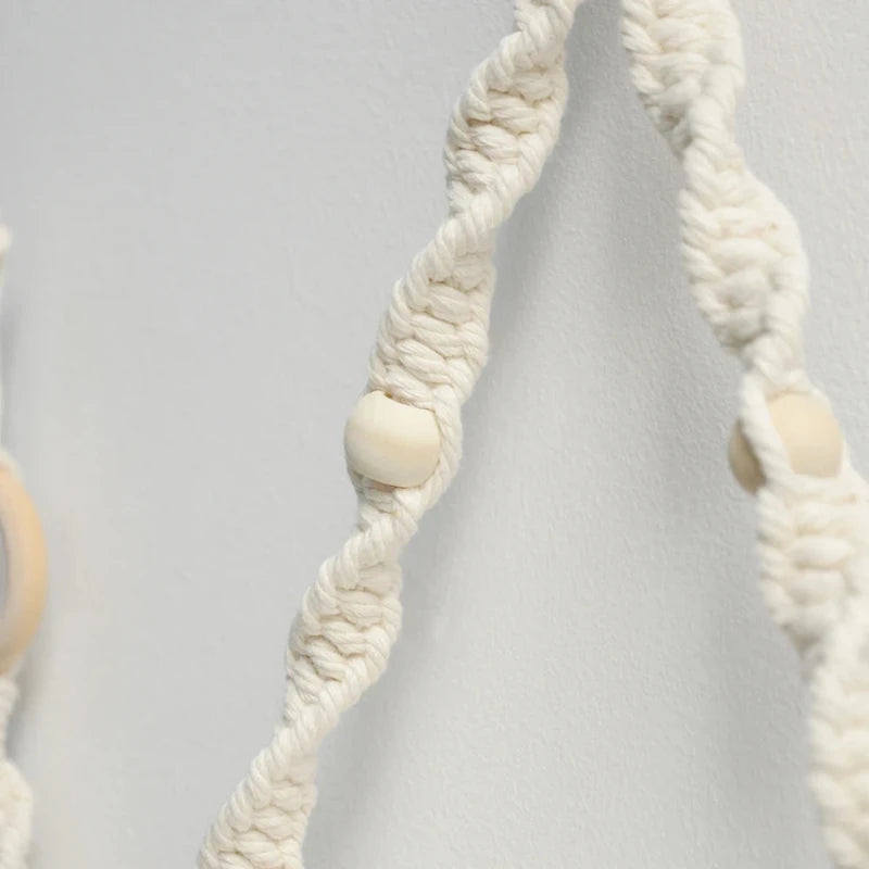 Détail de la perle en bois dans le macramé du porte-papier toilette mural