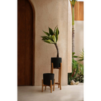 Deux jardinières noires en terre cuite avec supports en bois naturel, hauteur 68 cm