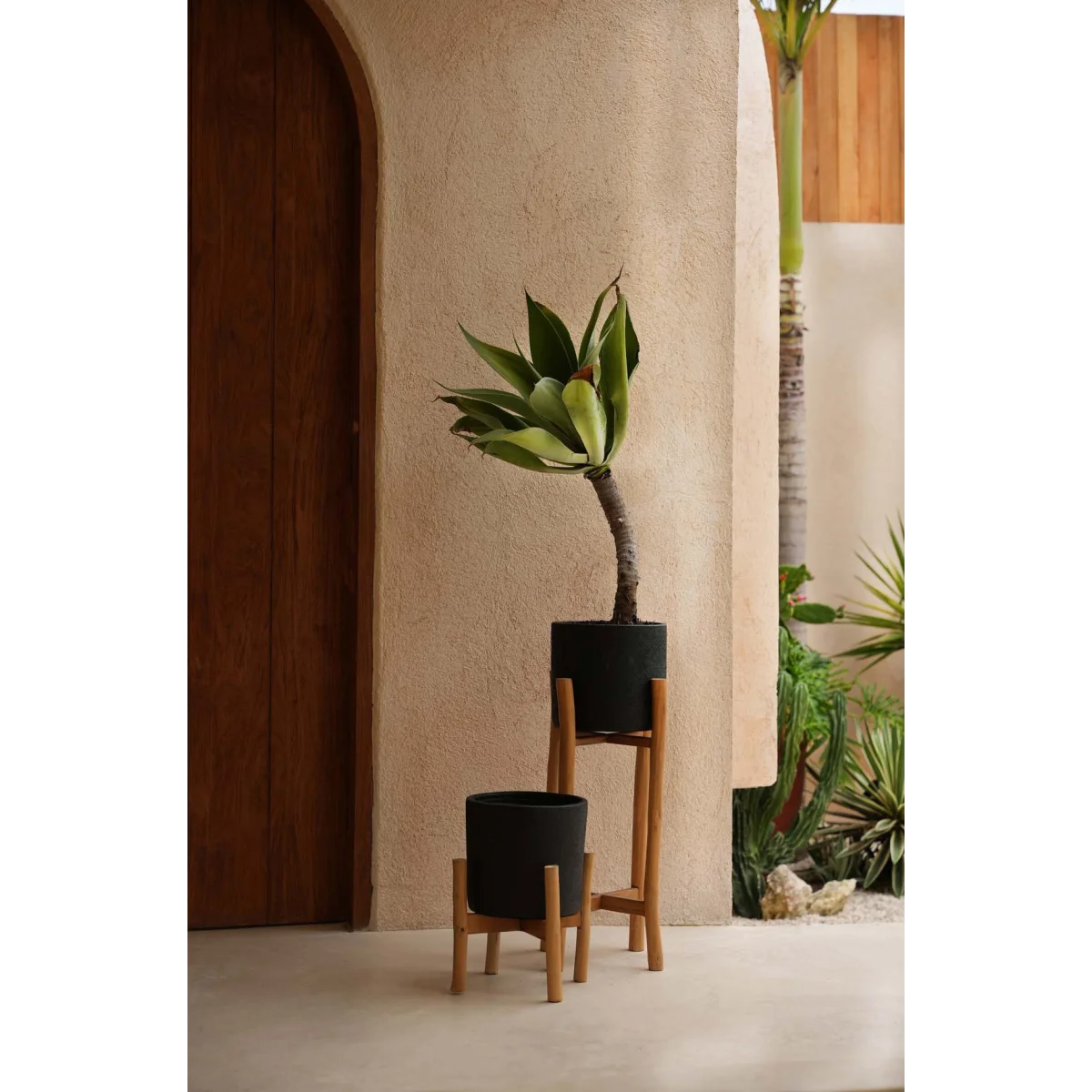Deux jardinières noires en terre cuite avec supports en bois naturel, hauteur 68 cm