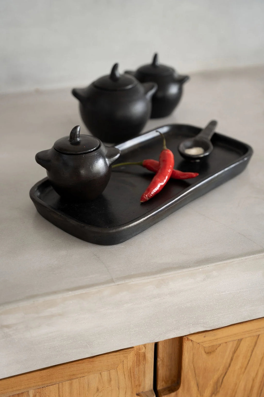 Plateau céramique noir avec 3 théières et poivrons rouges