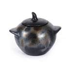 Vase en poterie noire avec couvercle et anses, Le pot brûlé