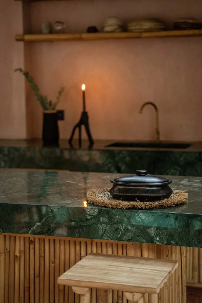 Pot ovale noir avec couvercle noir sur tapis en osier pour décoration ou cuisine