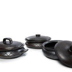 Trois pots en argile foncée avec couvercles, le pot ovale brûlé avec motif et poignées latérales noir