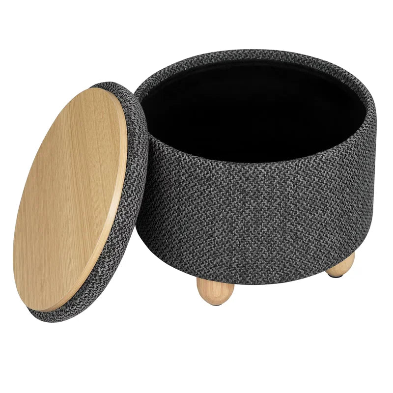 Pouf de rangement rond noir ouvert montrant son espace de stockage intérieur.