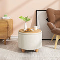 Pouf de rangement rond utilisé comme table d’appoint, décoré avec une tasse et une assiette.