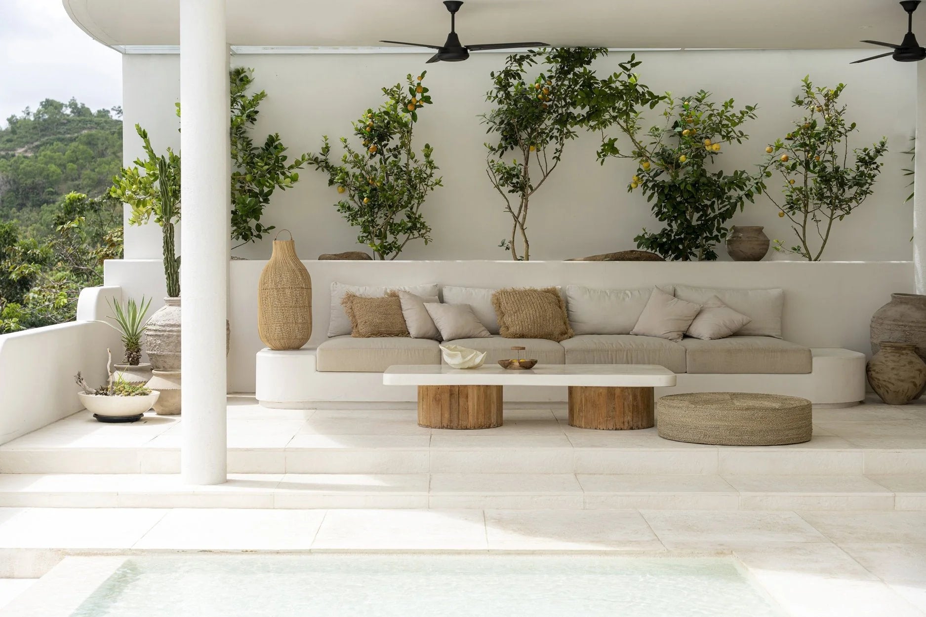 Image d’un espace détente extérieur avec un pouf rond en jonc de mer naturel