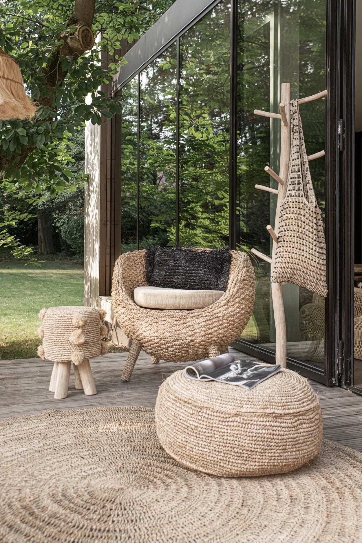 Pouf rond en raphia tressé naturel dans un ensemble de mobilier d’extérieur en osier