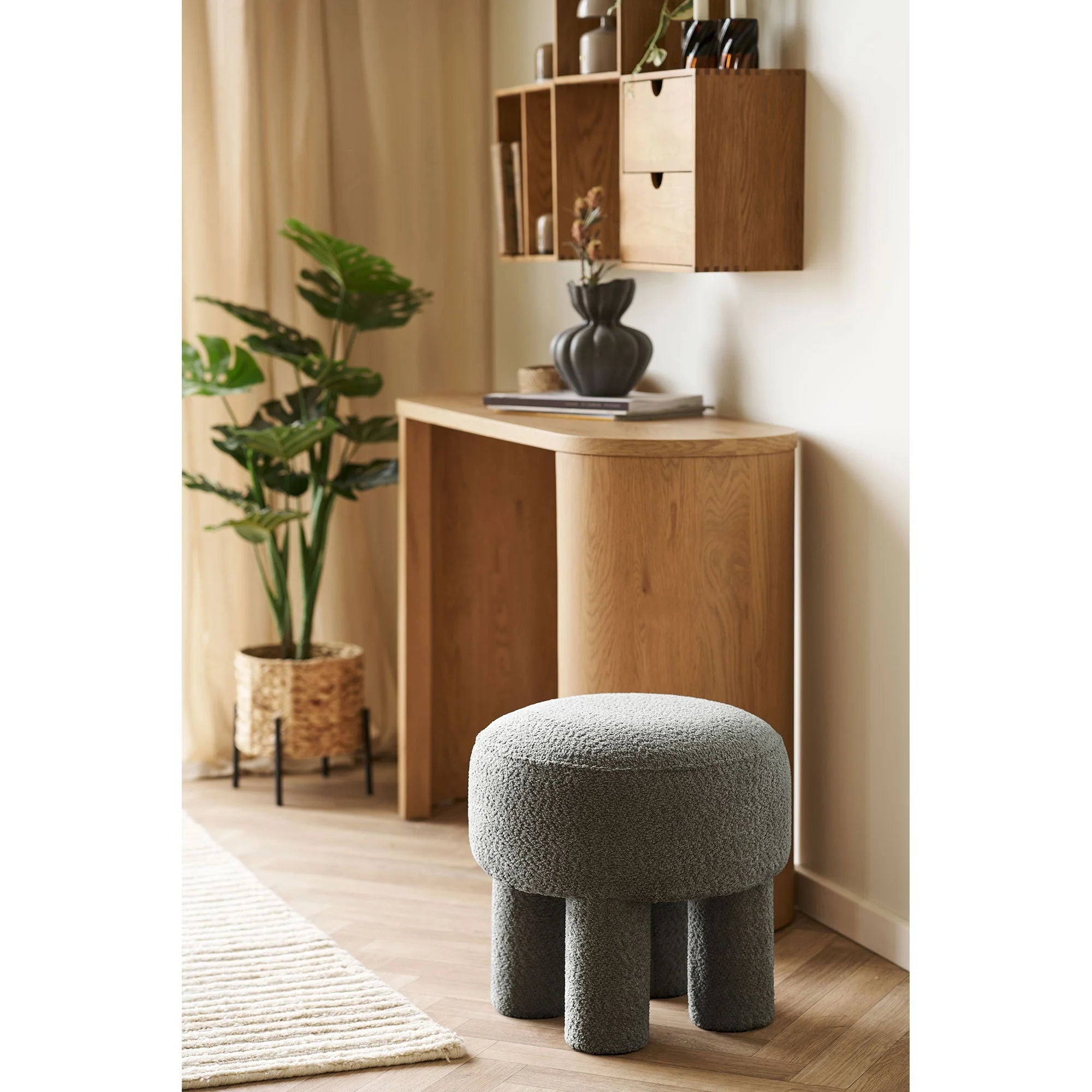 Pouf rond en tissu bouclé gris foncé avec trois pieds cylindriques, diamètre 43 cm