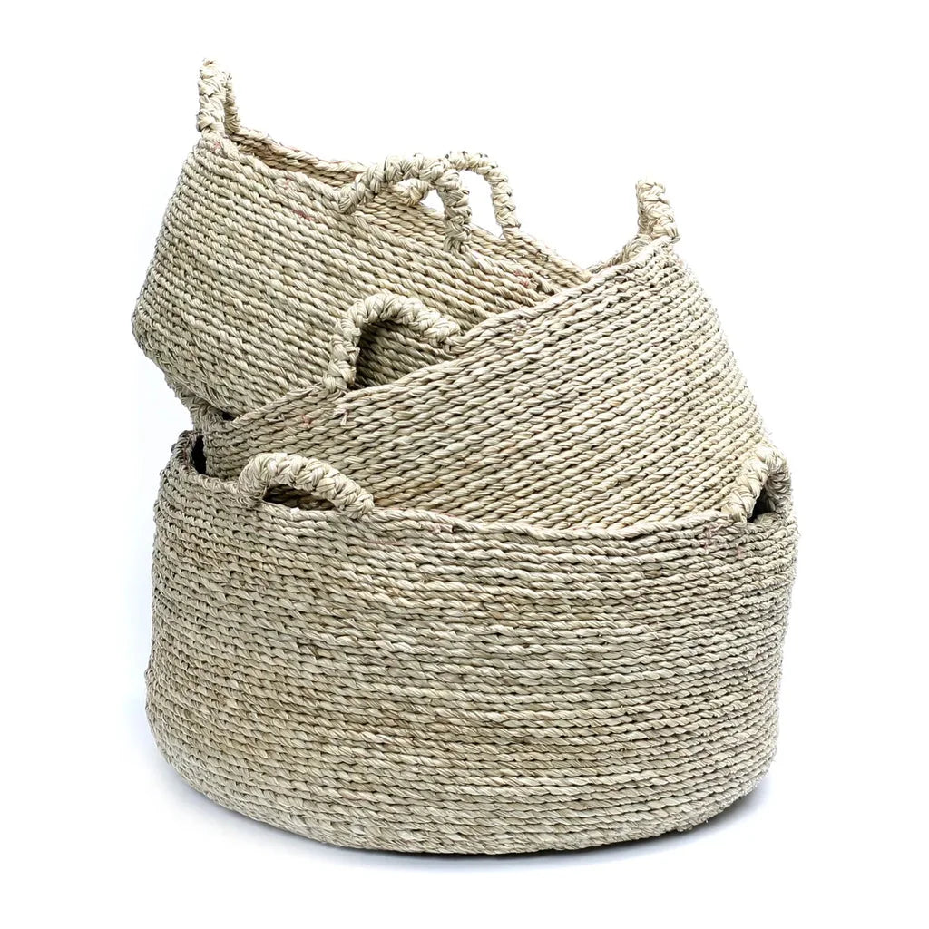 Pile de paniers tissés naturels pour Les Quatre Mains Baskets M