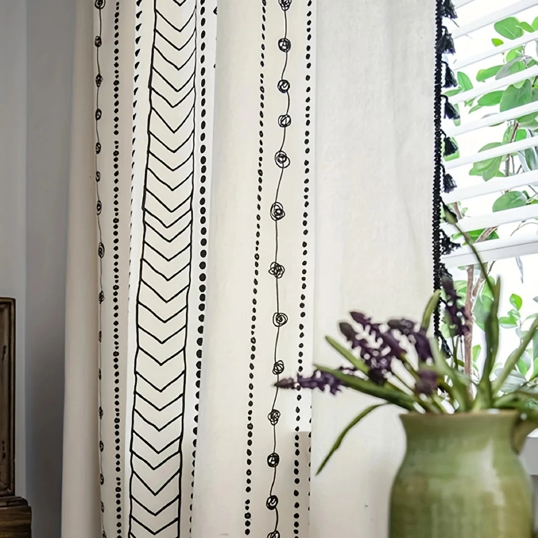 Rideau bohème à motifs géométriques noirs et blancs en situation dans un salon moderne.