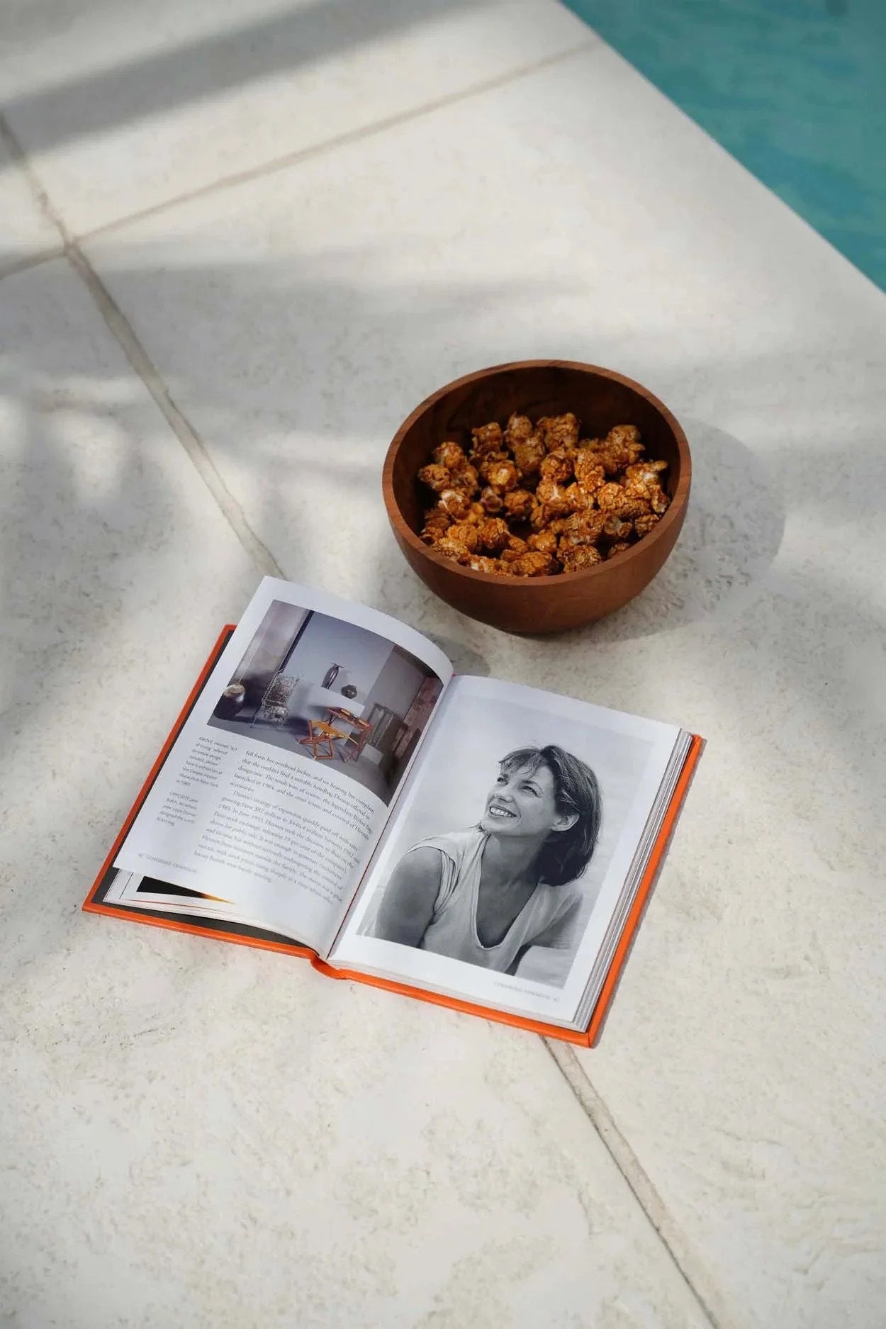 Livre ouvert avec portrait et bol de caramel corn sur un saladier rond en bois de teck naturel