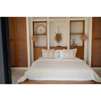 Lit bien fait avec linge clair, parfait pour la décoration circulaire en bois naturel