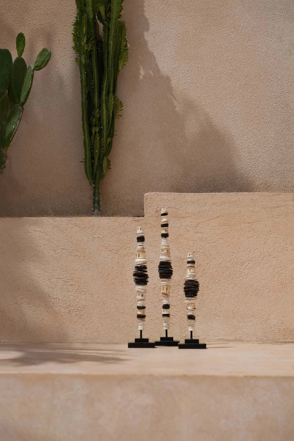 Totem de sculptures en coquilles noires et crème empilées sur socle artisanal, H55 cm